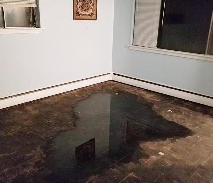 Soaked floor and walls after storm flooding and water damage