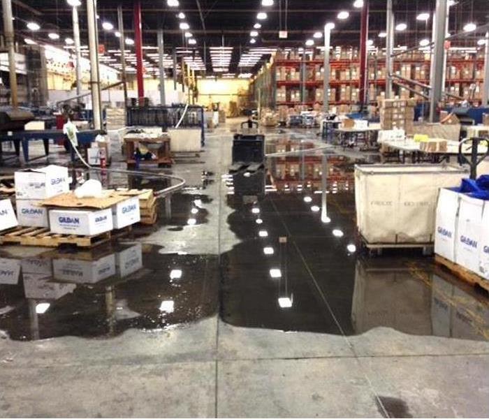 Commercial warehouse with flood damage and water puddles on floor