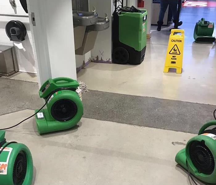 Air movers and dehumidifiers setup to dry retail water damage