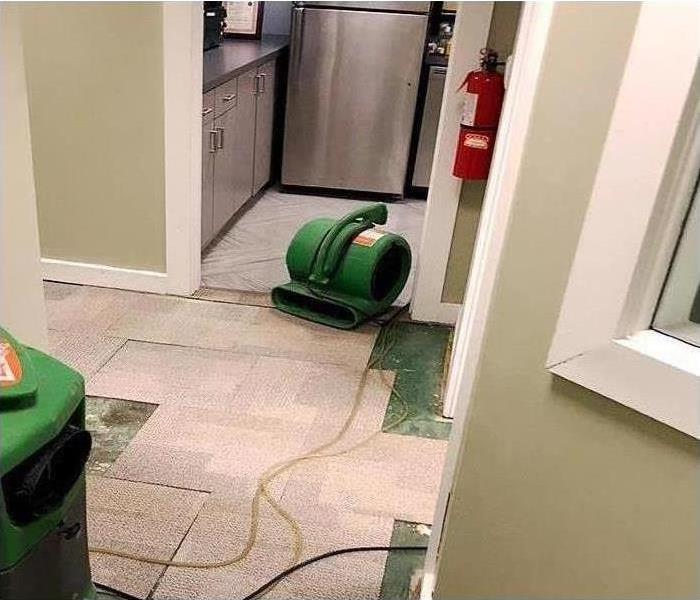 drying equipment setup during water damage restoration in office kitchen
